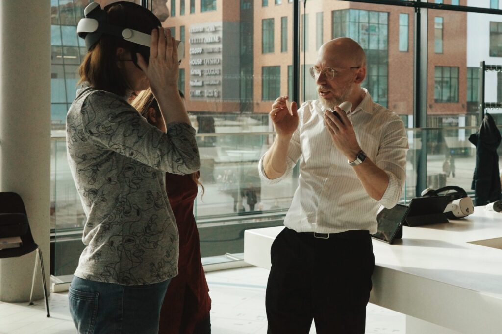 Autor projektu Radosław Wesołowski rozmawia z uczestniczką w okularach VR