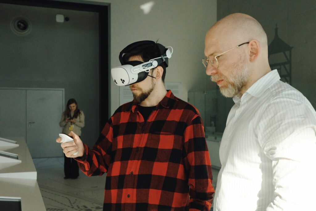 Uczestnik w okularach VR i z kontrolerem w dłoni i autor projektu.